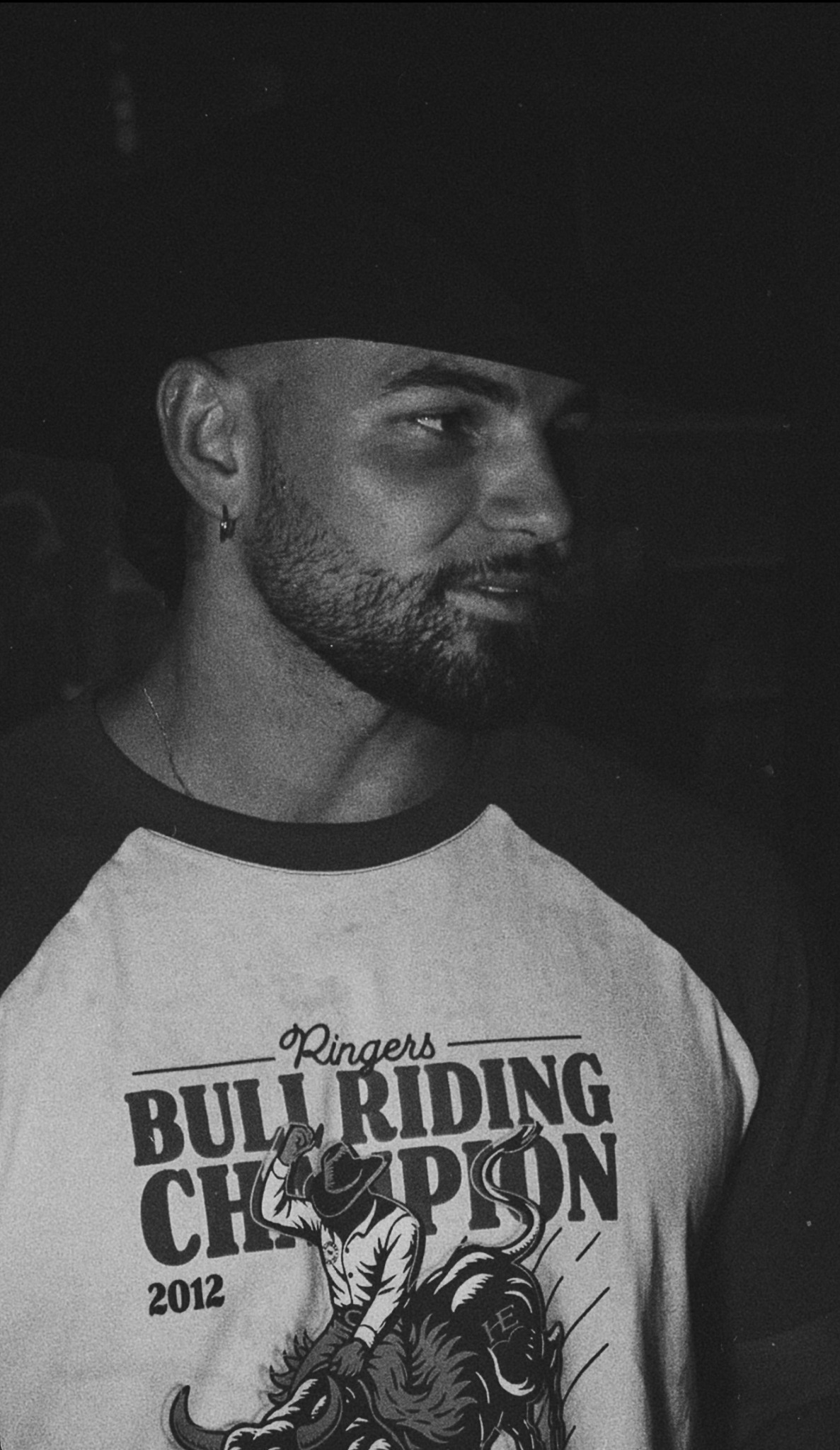 Black-and-white portrait of Emersxn wearing a Ringers Western bull riding shirt and cowboy hat