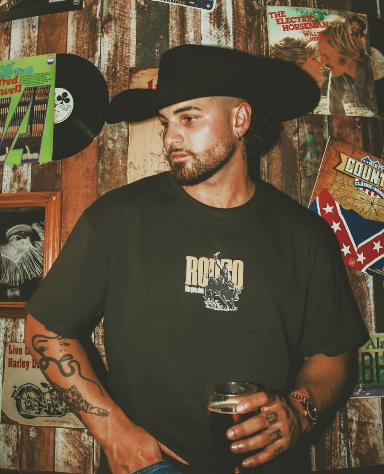 Emersxn in a black Ringers Western rodeo shirt and cowboy hat